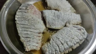 Aşçı tavada taze haç balığı kızartıyor.