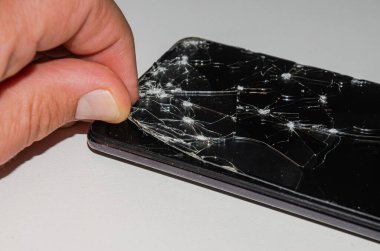 Servis merkezindeki usta akıllı telefondaki kırık camları değiştiriyor.