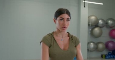 Brunette girl kneads shoulder joints and muscles, rotates her arms