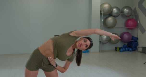 Athletic brunette girl performs a tilt to the left side — Αρχείο Βίντεο