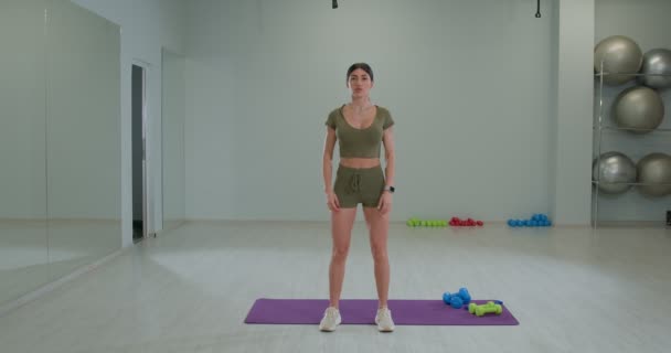 Sportief brunette meisje voert een warm-up voor handen — Stockvideo
