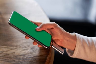 Kadının elinde bir telefon tutan eli.