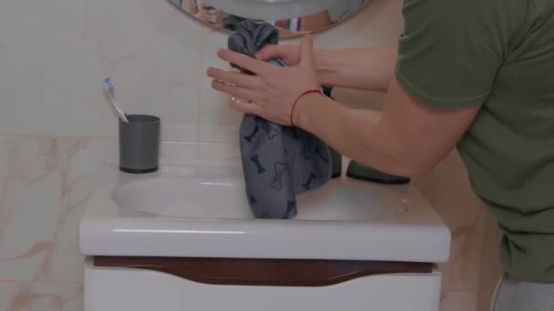 Férfi kéz mossa a ruhát, és kitekeri a mosogatóban. — Stock videók