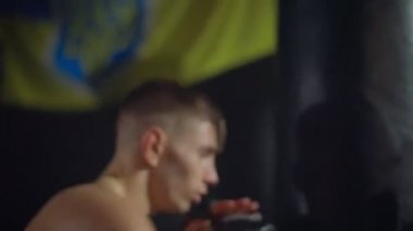 Bir boksör kollarını ve bacaklarını kullanarak kum torbasına seri yumruklar atar.