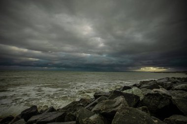 Dalgalar, bulutlar ve taşlarla Karadeniz üzerindeki dramatik gökyüzü