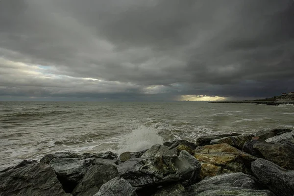 Dramatische lucht boven de zwarte zee met golven, wolken en stenen — Stockfoto