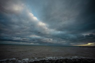 Dalgalar, bulutlar ve taşlarla Karadeniz üzerindeki dramatik gökyüzü