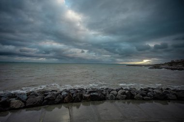 Dalgalar, bulutlar ve taşlarla Karadeniz üzerindeki dramatik gökyüzü