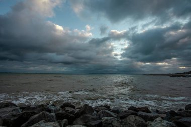 Dalgalar, bulutlar ve taşlarla Karadeniz üzerindeki dramatik gökyüzü