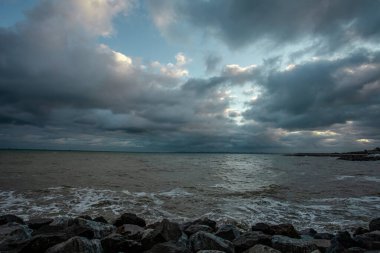 Dalgalar, bulutlar ve taşlarla Karadeniz üzerindeki dramatik gökyüzü