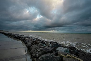 Dalgalar, bulutlar ve taşlarla Karadeniz üzerindeki dramatik gökyüzü