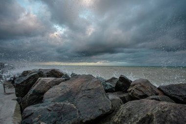 Dalgalar, bulutlar ve taşlarla Karadeniz üzerindeki dramatik gökyüzü