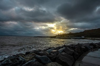 Dalgalar, bulutlar ve taşlarla Karadeniz üzerindeki dramatik gökyüzü