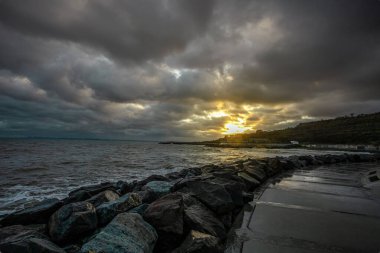 Dalgalar, bulutlar ve taşlarla Karadeniz üzerindeki dramatik gökyüzü