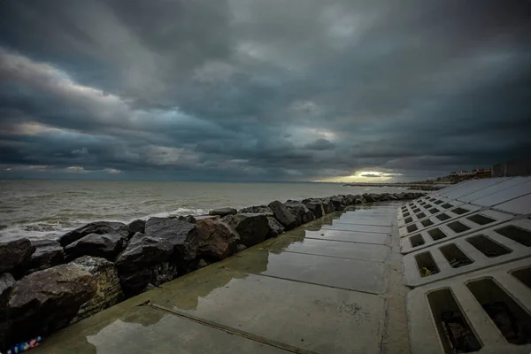 Cielo dramático sobre el mar negro con olas, nubes y piedras —  Fotos de Stock