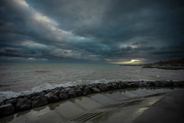 Cielo dramático sobre el mar negro con olas, nubes y piedras —  Fotos de Stock