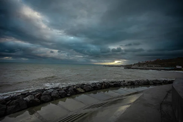 Cielo dramático sobre el mar negro con olas, nubes y piedras —  Fotos de Stock