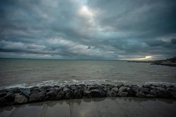 Cielo dramático sobre el mar negro con olas, nubes y piedras — Foto de Stock