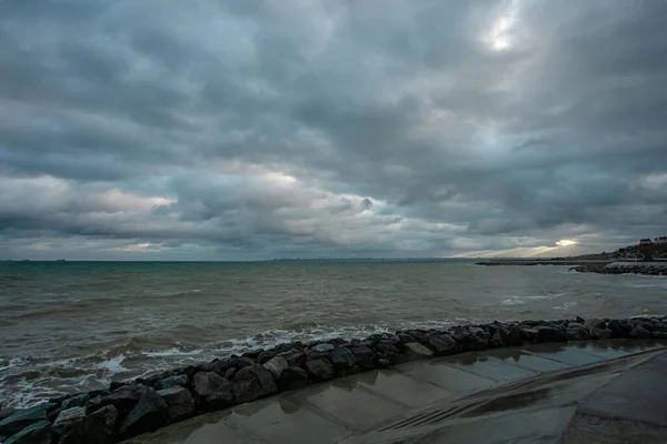 Dramatische lucht boven de zwarte zee met golven, wolken en stenen — Stockfoto