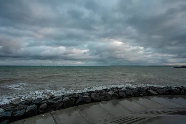 Cielo dramático sobre el mar negro con olas, nubes y piedras —  Fotos de Stock