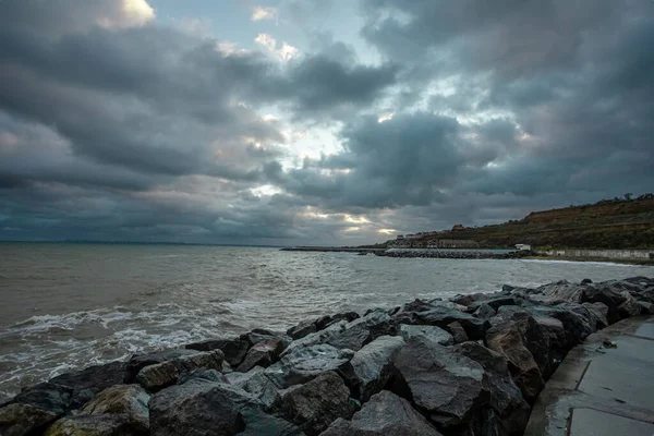 Cielo dramático sobre el mar negro con olas, nubes y piedras — Foto de Stock