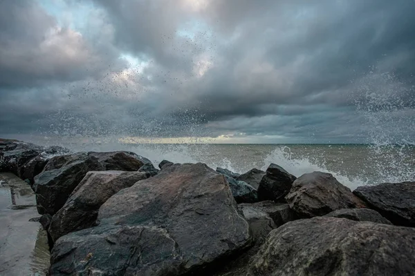 Cielo dramático sobre el mar negro con olas, nubes y piedras — Foto de Stock