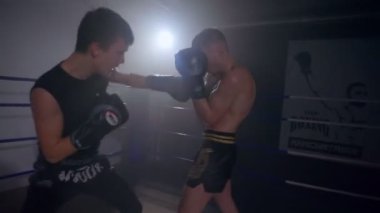 Yumruk yastığı kullanan bir arkadaşla süper hafif boksör eğitimi.