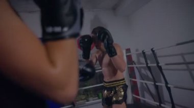 Yumruk yastığı kullanan bir arkadaşla süper hafif boksör eğitimi.