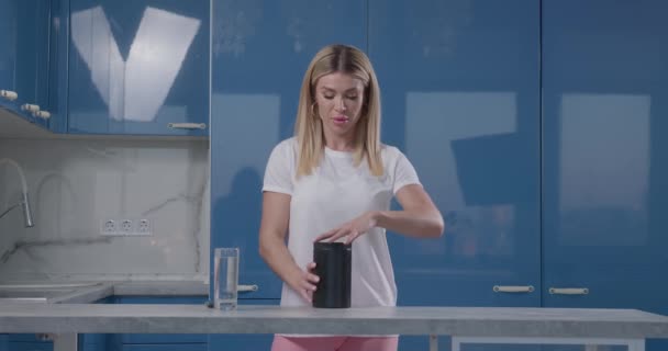 Κορίτσι αναδεύει αθλητική διατροφή bcaa σε ένα ποτήρι νερό — Αρχείο Βίντεο