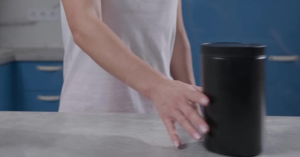 男男女女手在厨房桌子上相互推着黑罐子 — 图库视频影像