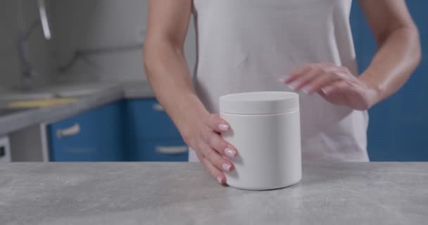 Γυναικείο χέρι αρπάζει λευκό βάζο και ξεβιδώνει το καπάκι σε αυτό — Αρχείο Βίντεο