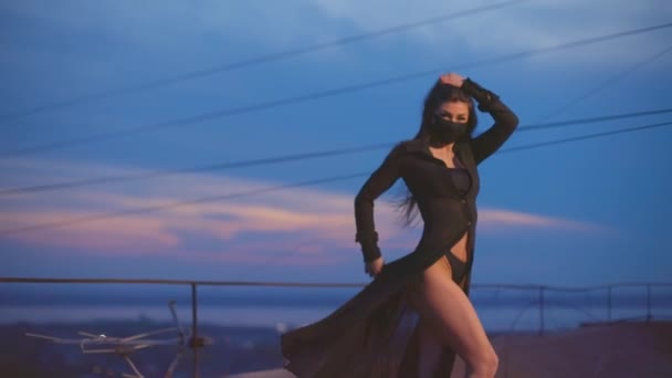 Menina em roupas transparentes e poses máscara para a câmera no telhado — Vídeo de Stock