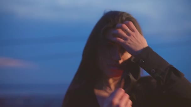 Bruna toglie la maschera nera al tramonto sul tetto — Video Stock