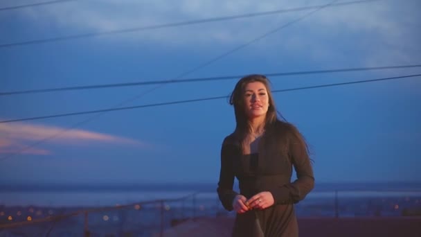 Aantrekkelijk meisje kijkt naar camera en toont middelvinger op dak — Stockvideo