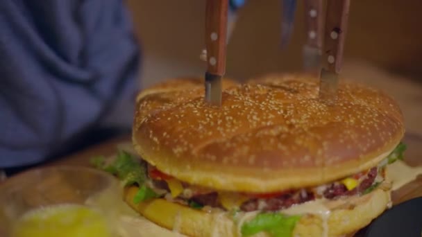 Mužské ruce řežou obří burger nožem — Stock video