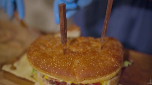 Obrovský burger v popředí, řezání v pozadí — Stock video