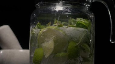Bir mojito yaratma süreci, su bir sürahiye dökülür.