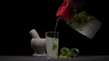 Bir sürahide mojito bardağa doldurulur.