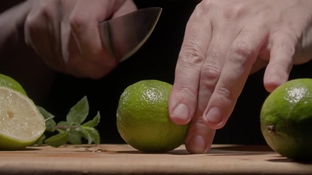 Male hands cut green lime with a knife — Vídeo de stock