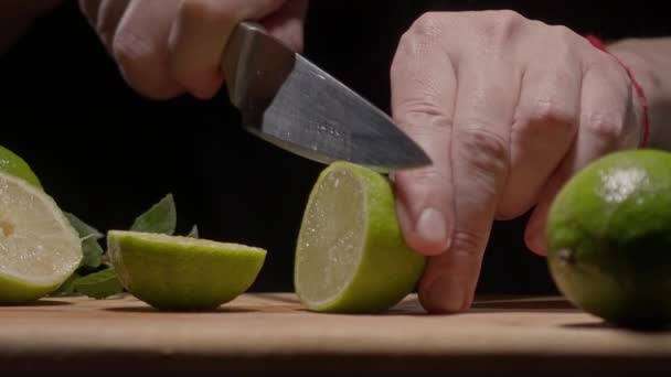 Male hands cut a slice of green lime — Vídeo de stock