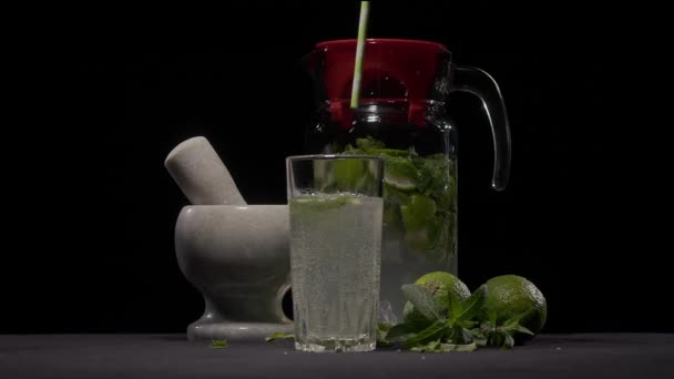 A mans hand lowers a straw into a glass of mojito — Wideo stockowe