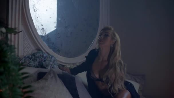 Spektakulär blond kvinna rätar ut håret framför en vintage spegel — Stockvideo