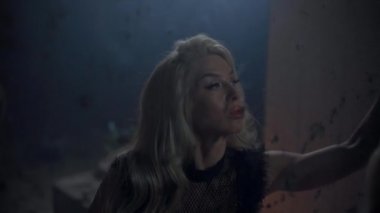 Güzel sarışın kadın aynayı eliyle siliyor.