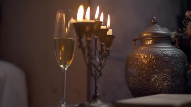 Brandende kaarsen en een glas champagne in vintage interieur — Stockvideo