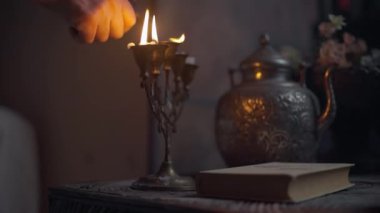 Erkek el şamdandaki mumları hareket ettirir ve mumları söndürür.