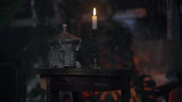 Die Kerze steht im Gewächshaus auf dem Tisch und verblasst — Stockvideo