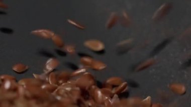 Kahverengi keten tohumu bir Omega 3 kaynağı büyük miktarlarda siyah bir zemin üzerine dökülür, keten tohumu yağı üretimi