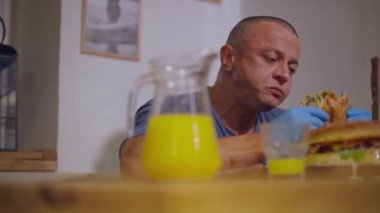 Yetişkin, kel bir adam eldiven takmış ve iyice çiğniyor.