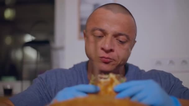 흰머리 남자가 장갑을 햄버거를 씹는다 — 비디오