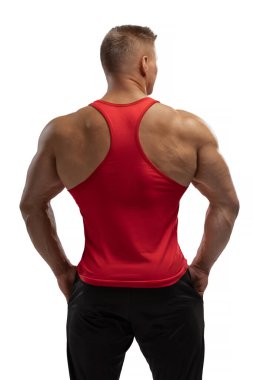 Stüdyodaki beyaz siklonamada kırmızı kolsuz tişörtlü çekici bir atletin portresi. Spor yaşam tarzı..